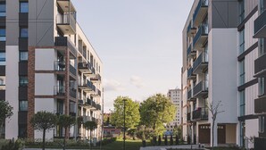 A modern residential building with multiple balconies, a central pathway, and a well-maintained garden area. - Industria Apartment Zawisza Parking Balkon (Bydgoszcz)