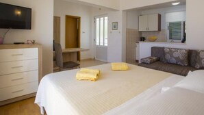 A hotel room with a large bed, a desk, a sofa, and a television. - Sea View Apartments Lendic Podgora (Podgora)