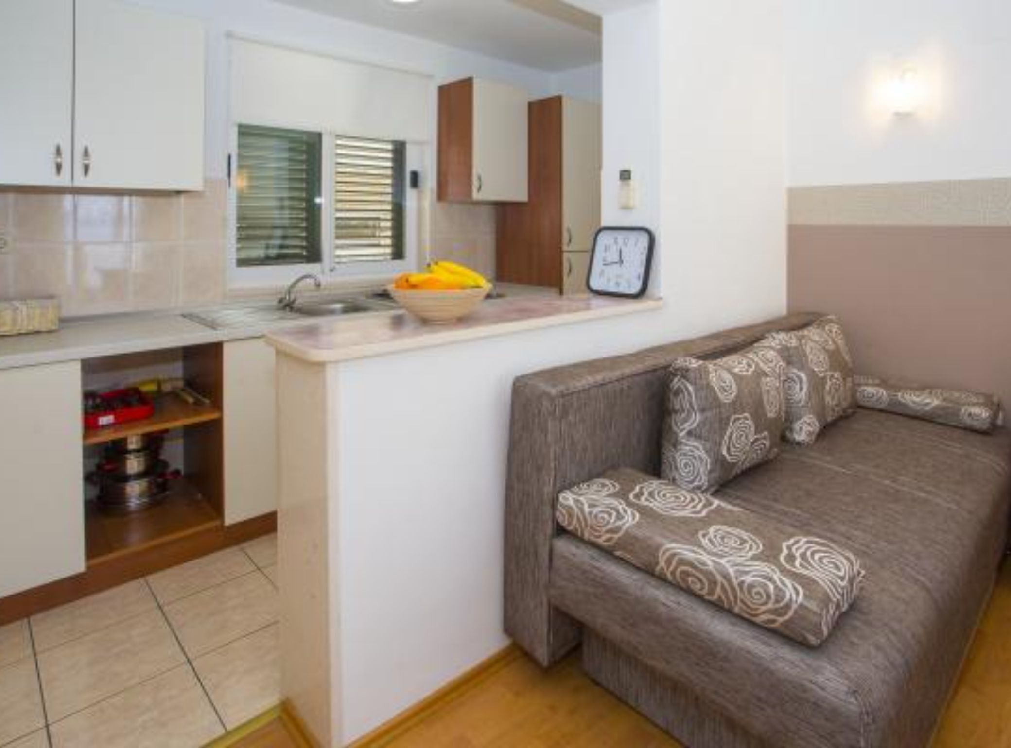 Un espacio habitable compacto con kitchenette, un sofá y un pequeño comedor.
