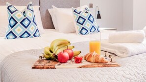 A neatly made bed with a breakfast tray, pillows, and a painting on the wall. - Stunning Studio - Sleeps 4 (Staines)