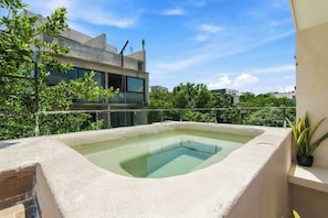 A rooftop swimming pool with a clear view of a modern building in the background. - Bright Tulum 2BR - Rooftop Pool near Aldea Zama (Tulum)