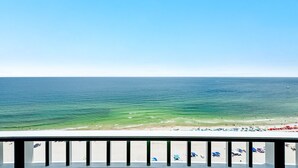 A balcony with a view of the ocean and beach.