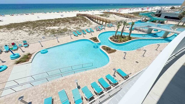 A resort with a large pool area, multiple water slides, and a beach.