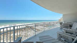 A balcony with a view of a beach and ocean.