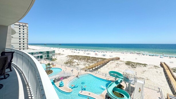 A resort with a pool area, a water slide, and a beach view. - New Complex!  Beachfront 4BR, 5TH FLOOR!, Lazy River and Water Slide! (Gulf Shores)
