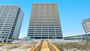 A modern high-rise hotel with multiple balconies, a prominent entrance, and a beachside location. - New Complex!  Beachfront 4BR, 5TH FLOOR!, Lazy River and Water Slide! (Gulf Shores)