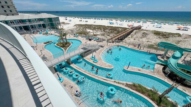A resort with multiple swimming pools, a beach area, and a water slide. - New Complex!  Beachfront 3BR! 4TH FLOOR!!  LAZY RIVER and WATER SLIDE!! (Gulf Shores)