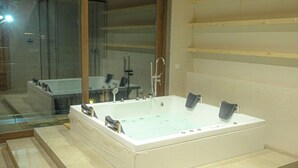 A modern bathroom with a large freestanding bathtub, a glass shower enclosure, and a wooden ceiling. - RajBagh Shimla (Shimla)