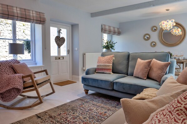 A cozy living room with a blue sofa, a rocking chair, and a patterned rug. - Cottage in Bakewell Near Peak District (Bakewell)