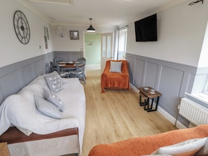 A room with a bed, a sofa, a table, and a TV. - Southfields Annex (Louth)