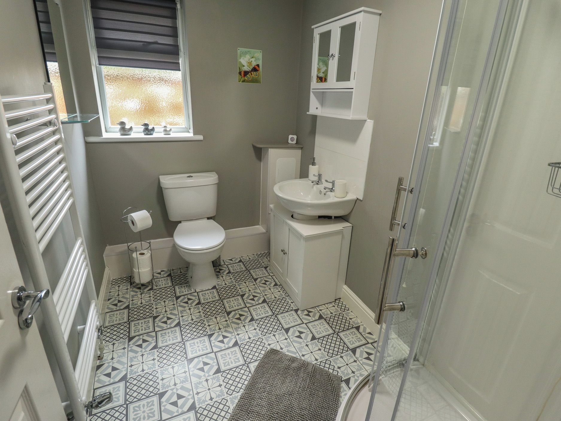 A bathroom with a toilet, sink, and shower area.
