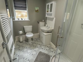 A bathroom with a toilet, sink, and shower area.