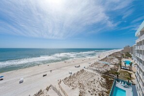A beach view with a hotel and a swimming pool. - Crystal Shores West 208 (Gulf Shores)