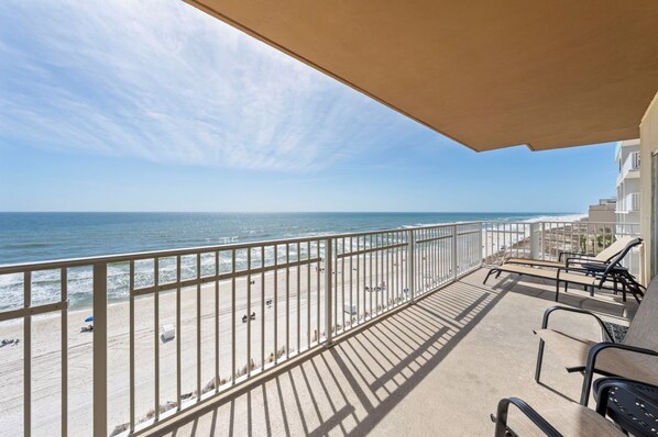 Un balcon avec vue sur la plage et l’océan.