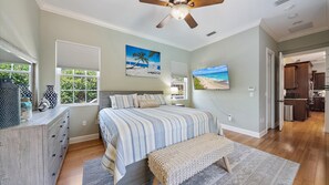 A bedroom with a bed, bedside table, lamp, and artwork. - Sapphire Shores 3 Bedroom Home (Sarasota)