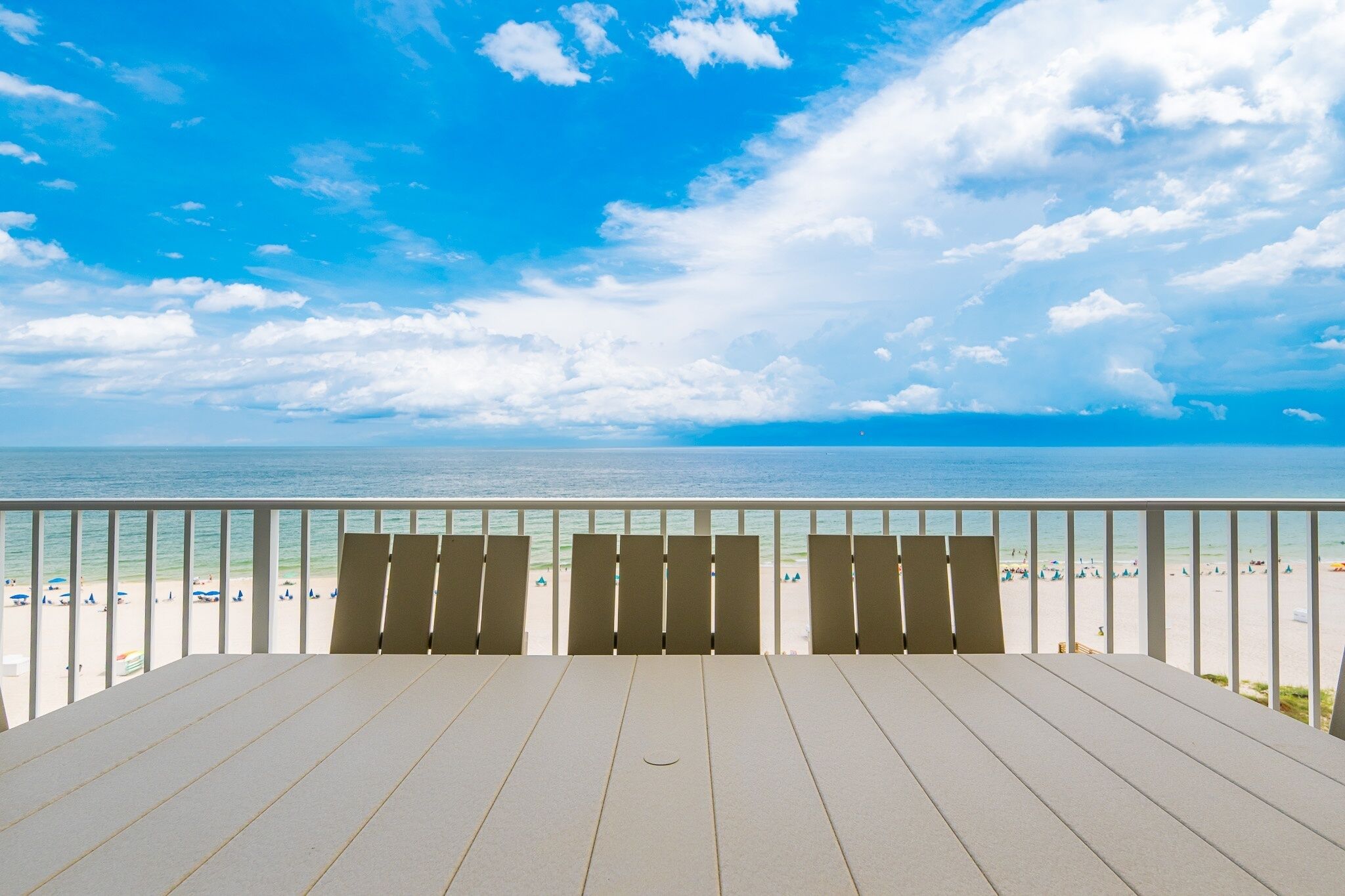 A balcony with a view of a beach and ocean.