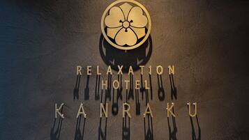 Un logotipo con un emblema circular y el texto 'RELAXATION HOTEL KANRAKU'.