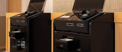 Two self-service kiosks with card readers, a coffee machine, and a water dispenser.