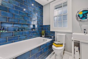 A bathroom with a white bathtub, a toilet, and a sink. - Little Redlap in Dartmouth (Dartmouth)