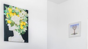Ein Wohnzimmer mit Flachbildfernseher, einem Glastisch, einem Blumentopf und einem gerahmten Bild an der Wand.