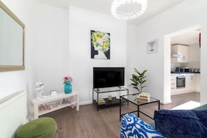 Relax in this stylish living room with a flat-screen TV, glass coffee table, and comfortable sofa.