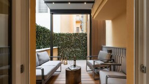 A modern outdoor seating area with a wooden floor, two sofas, and a coffee table.