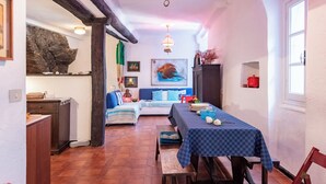 Un coin repas accueillant avec une table dressée pour deux personnes, un canapé et un tableau accroché au mur.