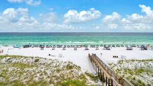 A beach with a wooden pier, sandy beach, and ocean view. - 🐬Crystal Sands 306B - Summer Salt | Gulf Views + Heated Community Pool (Destin)