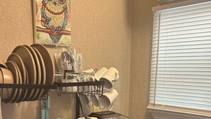 Una cocina compacta con lavamanos, estufa y escurreplatos.