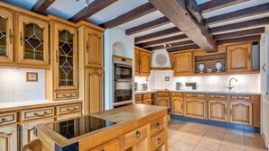 A kitchen with wooden cabinets, a central island, and a built-in oven. - Cottage in Bridgnorth With Hot Tub & Garden (Bridgnorth)