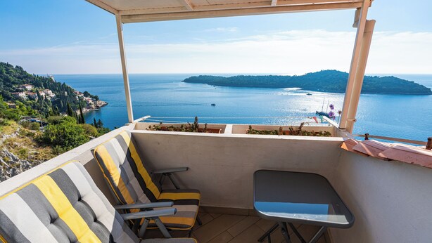 Ein Balkon mit Meerblick, einer Couch und einem kleinen Tisch.