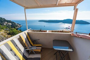 A balcony with a view of the sea, a sofa, and a small table. - Apartment Blue Horizon (Dubrovnik)