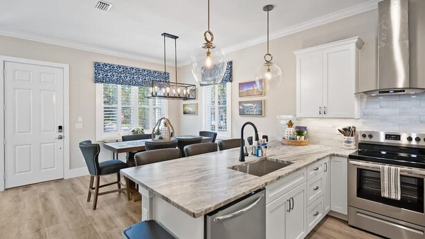 A modern kitchen with a central island, stainless steel appliances, and pendant lighting. - 2 Steps to Ice Plant Downtown St Aug Beach Club (St. Augustine)