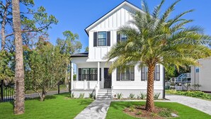 A two-story white house with a front porch, a palm tree, and a paved walkway. - 2 Steps to Ice Plant Downtown St Aug Beach Club (St. Augustine)