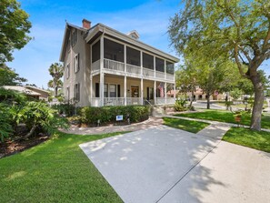 A two-story house with a front porch, a driveway, and a well-maintained lawn.