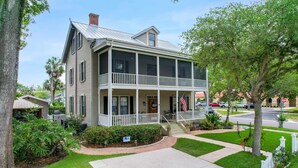A two-story house with a balcony, a front porch, and a driveway.