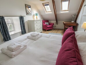 A bedroom with a bed, a dresser, a desk, a chair, and a window. - Ty Clyd (Newport)