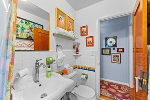 Une salle de bain avec un lavabo, des toilettes et un rideau de douche.