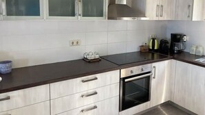 Een moderne keuken met witte kasten, een roestvrijstalen oven en een zwart aanrecht.