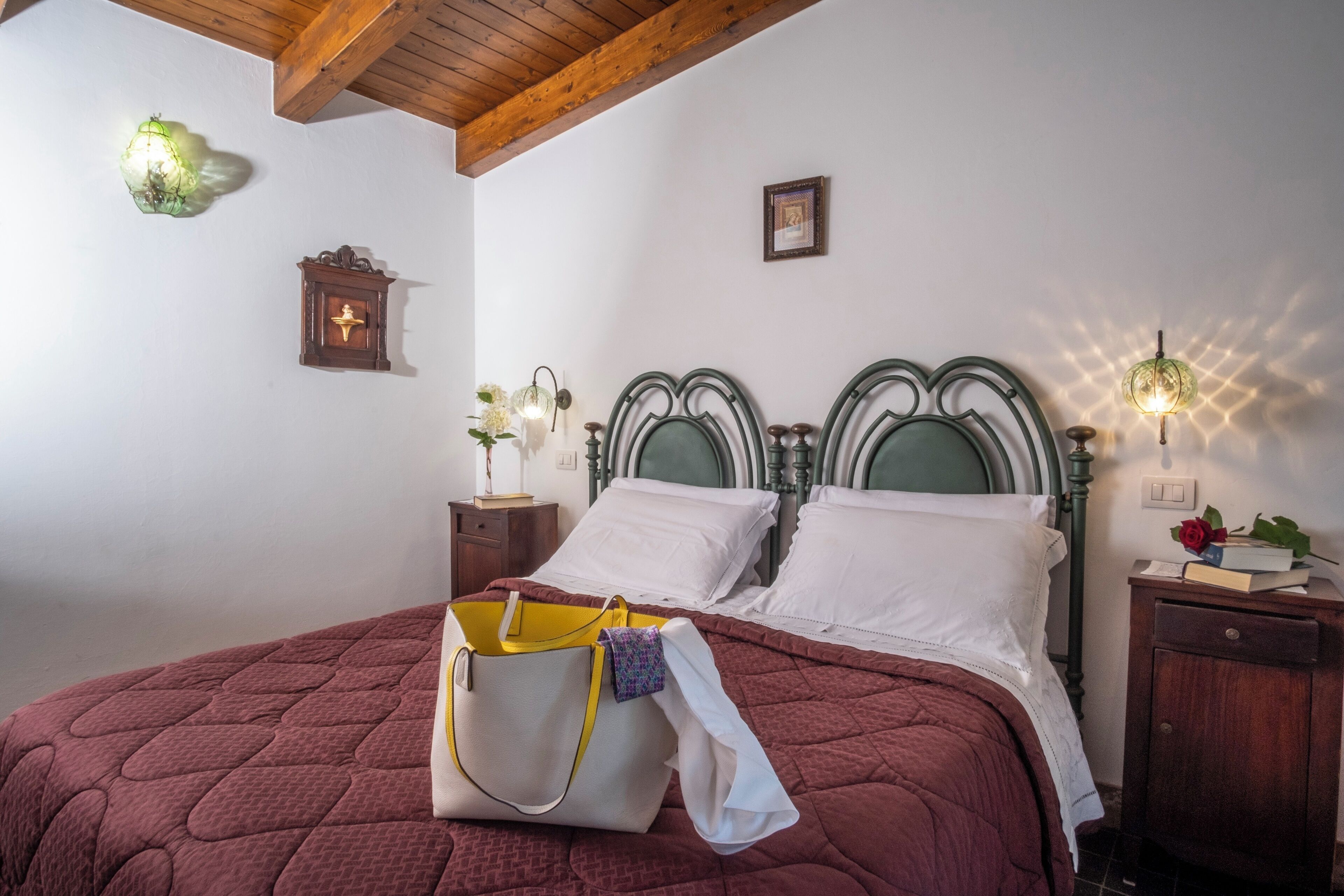 Un dormitorio con cama, mesita de noche, lámpara y un reloj de pared.
