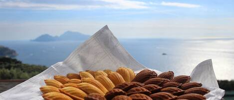 Un plateau de pâtisseries, avec en arrière-plan une vue magnifique sur la mer et les montagnes.