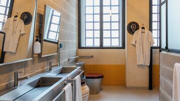 Un baño moderno con lavamanos dobles, un espejo grande y una ventana que proporciona luz natural.