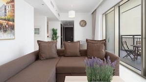 Una sala de estar moderna con un sofá marrón, una mesita y una planta en maceta.