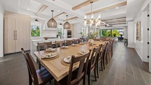 Una cocina amplia con una isla grande, armarios de madera e iluminación colgante.