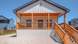 Un bâtiment à deux étages doté d’un porche couvert et d’un escalier menant à l’étage supérieur.