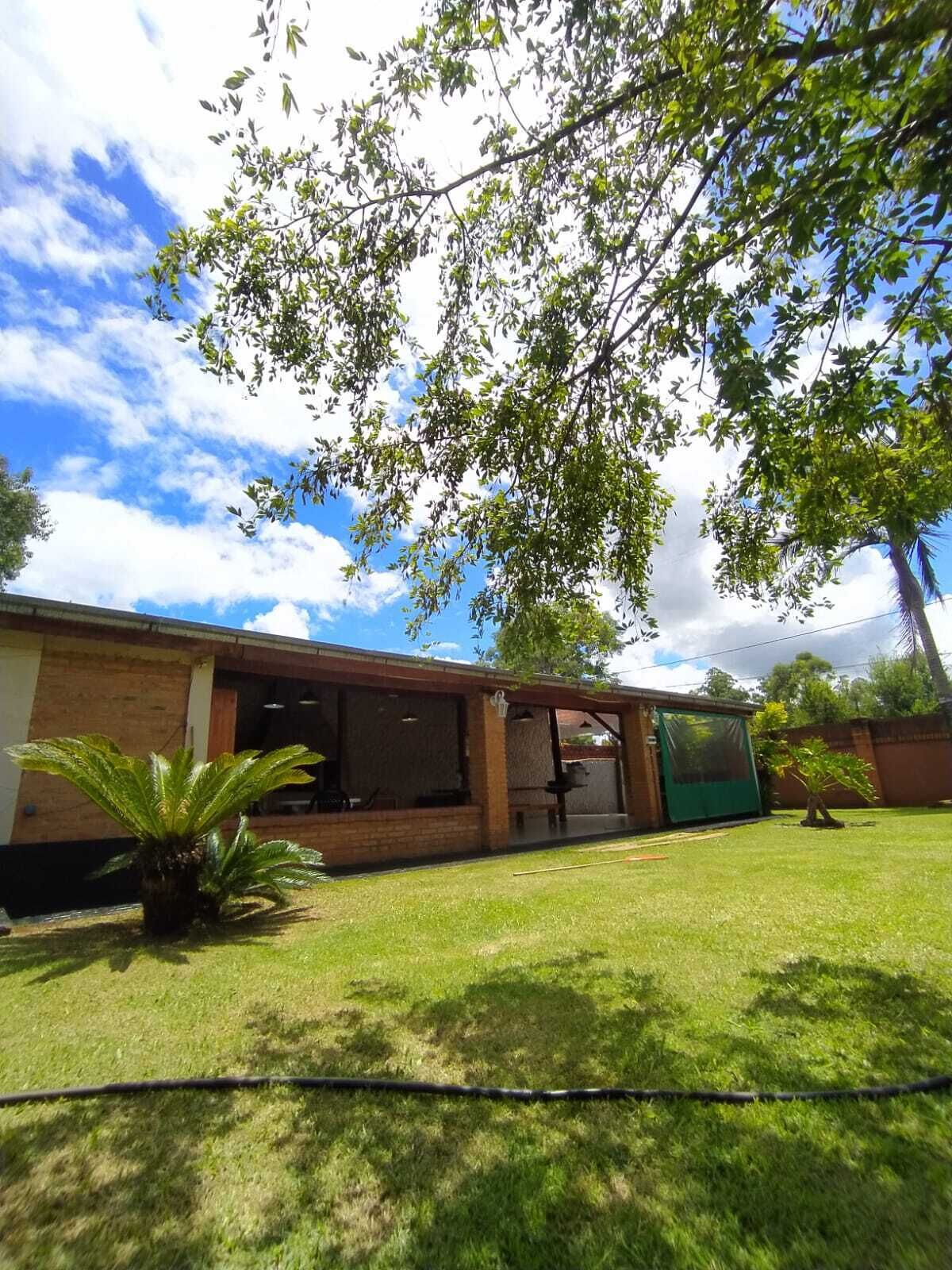A house with a brick exterior, a covered patio, and a lawn.
