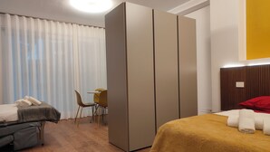 A hotel room with a bed, a desk, a chair, and a wardrobe. - CconfortHotels Maison 104 (Bari)