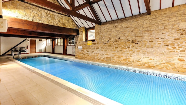 An indoor swimming pool with stone walls and wooden beams. - Cottage in Onibury Near Ludlow Castle (Craven Arms)