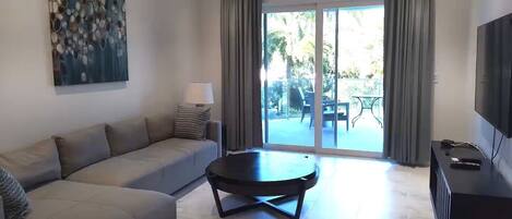 A modern living room with a sofa, a coffee table, and a TV.