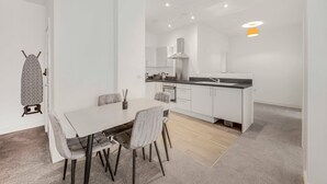 A modern kitchen with white cabinets, a black countertop, and a built-in oven.